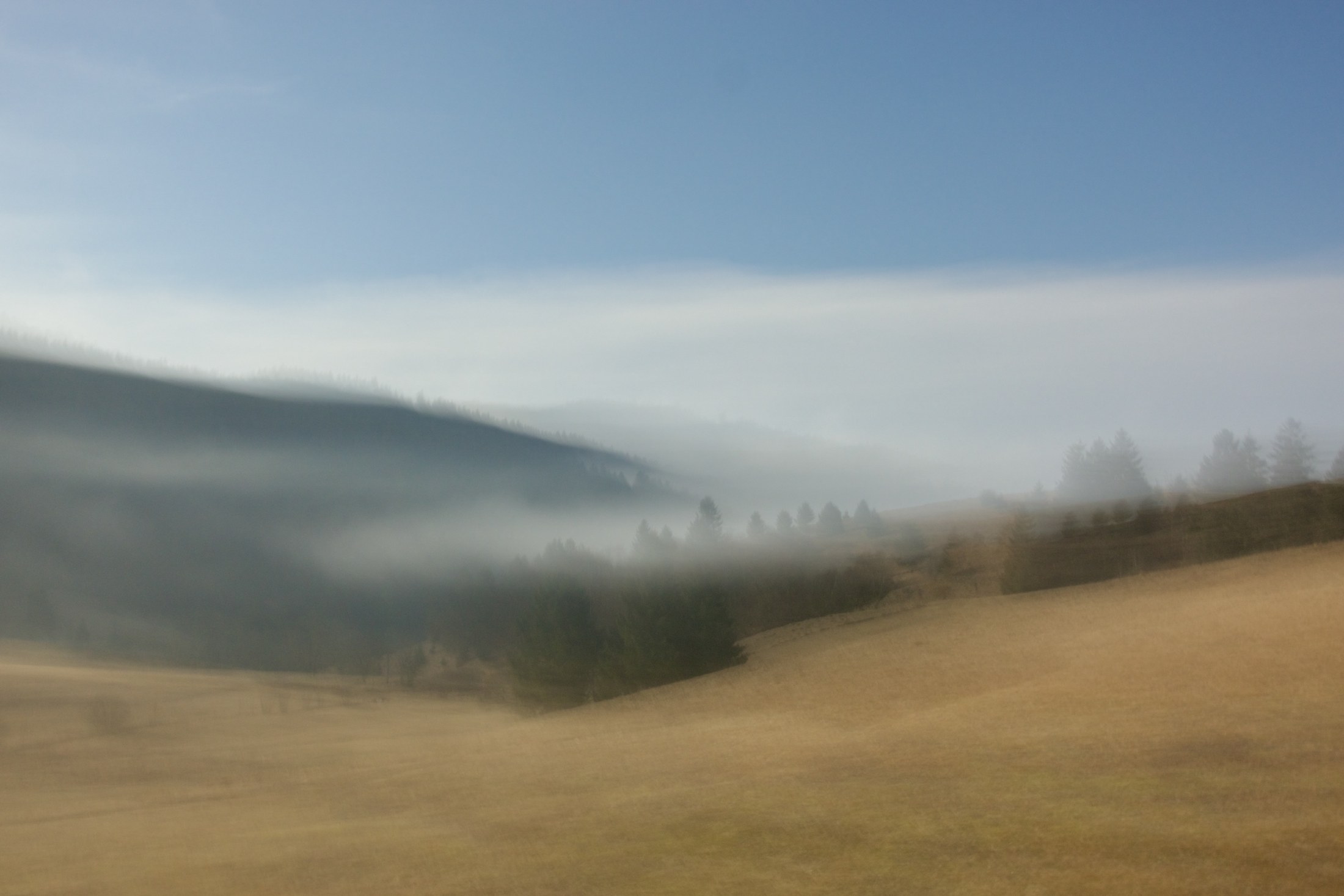 Impressionistische Nebellandschaft mit Hügeln und Wald